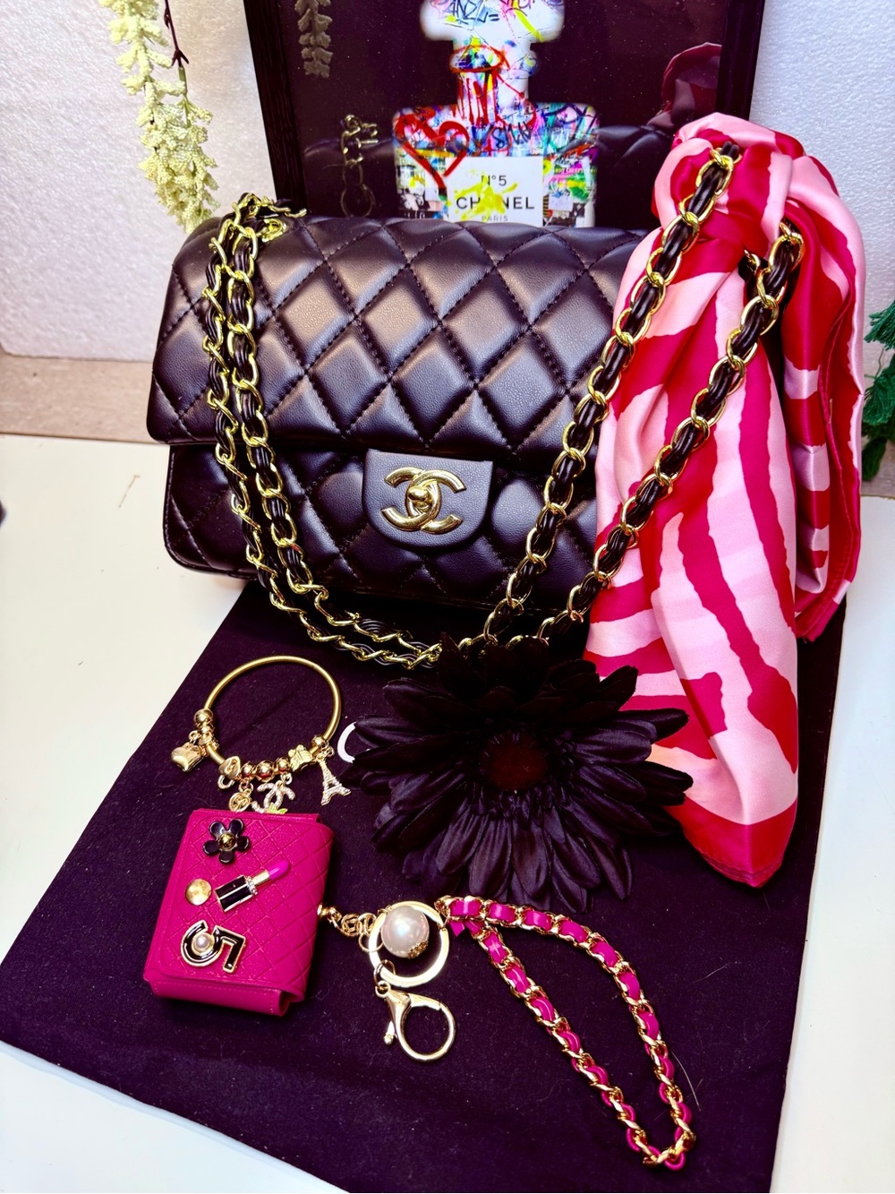 Black Quilted Shoulder Bag with Gold Tone Chain and Pink Scarf Accent